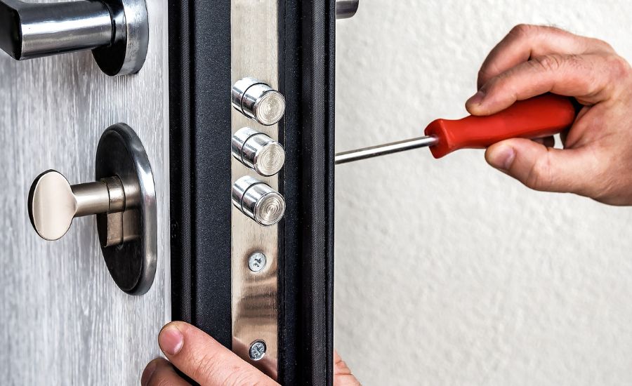 locked out of office man fixing lock with screwdriver